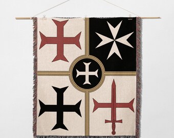 May include: A decorative wall hanging featuring a geometric design with crosses and a sword. The design incorporates red, black, and white crosses on a cream background, with a black and white starburst. The hanging is displayed on a wooden rod.