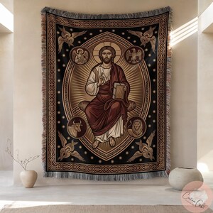 Könnte beinhalten: Ein gewebtes Wandtuch mit einer religiösen Ikone. Die zentrale Figur ist mit einem Heiligenschein dargestellt, hält ein Buch und ist von Symbolen und Engeln umgeben. Das Wandtuch hat einen schwarzen Hintergrund mit goldenen und braunen Akzenten und einen Fransenrand.