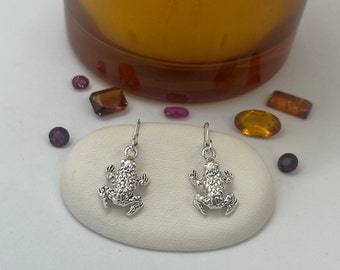 A Pair Of Silver Textured Frog Drop Style Earrings.