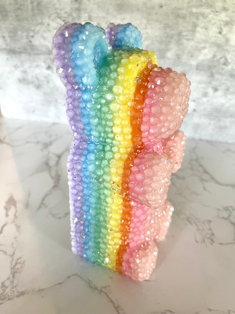 Pu&ograve; includere: Un orso gommoso arcobaleno con una finitura scintillante. L'orso &egrave; fatto di plastica trasparente e ha un motivo arcobaleno.