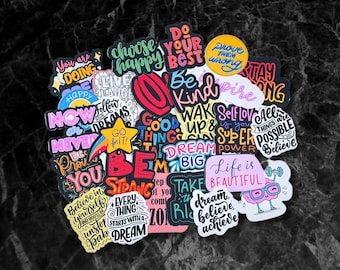Puede incluir: Una colección de pegatinas coloridas con mensajes motivacionales e inspiradores. Las pegatinas presentan frases como "Haz lo mejor", "Sé amable", "Sueña en grande", "La vida es hermosa" y "Cree en ti mismo".