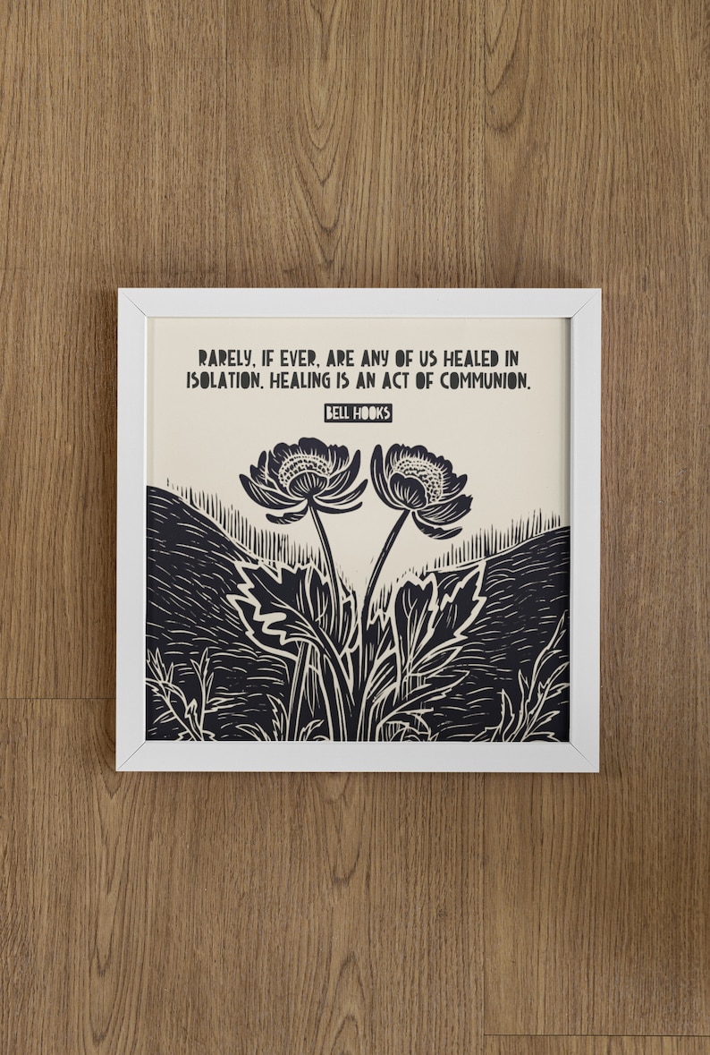 May include: A framed print with a black and white illustration of two flowers with a quote by Bell Hooks: "Rarely, if ever, are any of us healed in isolation. Healing is an act of communion."