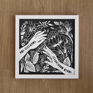 May include: Black and white illustration of two hands reaching up, surrounded by flowers and leaves. The text "NOS ELEVAMOS LEVANTANDO OTROS" is written on the hands.