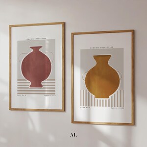 Puede incluir: Dos láminas enmarcadas con diseños abstractos de jarrones. Una lámina muestra un jarrón de color terracota, la otra un jarrón amarillo mostaza. Ambas tienen un fondo neutro con rayas verticales y el texto "Ceramic Collection".