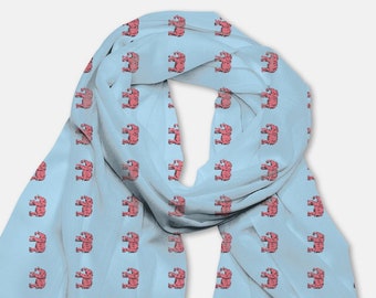 May include: A light blue scarf with a repeating pattern of pink elephants. The scarf has fringed edges.