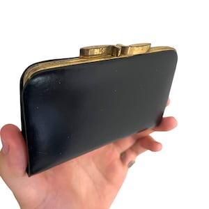 Cartera vintage de charol de los años 60 con hebilla de latón estilo art déco, bolso de mano retro moderno y monedero negro brillante.