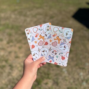 May include: Two white cards with a repeating pattern of cartoon mice wearing hats and holding teacups. The background is a light pink with hearts, stars, and bows.