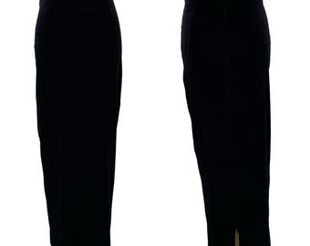 May include: Two views of a long, black velvet skirt. The skirt is floor-length with a straight silhouette. A slit is visible at the back hem. The fabric has a soft sheen, suggesting a formal or evening wear garment.