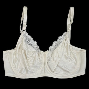May include: Ivory-colored bra with adjustable straps and a full coverage design. The bra features a satin-like fabric and delicate lace trim along the neckline. The underwire bra has a classic silhouette.