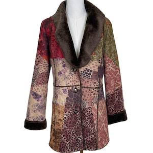 May include: A white ceramic mug with a black handle and the text "But First, Coffee" in a black, bold font. The mug is sitting on a wooden surface. The mug is approximately 4 inches tall.