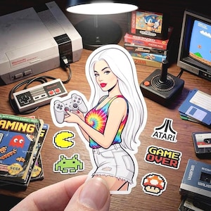 May include: A sticker of a woman with long white hair holding a video game controller, surrounded by retro gaming consoles, cartridges, and stickers. The woman wears a tie-dye top and denim shorts. Classic video game theme.