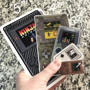 Retro Gameboy Stickers | Vintage Game Consoles with Well Known 8-bit Games on the Screens (Clear, Glossy or Holographic)