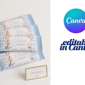 Puede incluir: Cuatro envoltorios rectangulares para barras de chocolate con un patrón de cuadros vichy azul claro, detalles florales e ilustraciones de una niña y un conejo. El texto dice Eloise Cumple 1. Un letrero dorado muestra la palabra Chocolates.