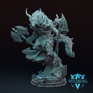 Può includere: Statuetta dettagliata di una creatura mitica con testa di lupo, corna e armatura intricata, che brandisce due asce e un bastone. La figura è posata su una base rocciosa, con il logo "Witchsong" visibile.