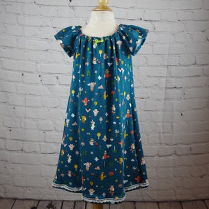 May include: A teal blue dress with a white lace trim. The dress has a gathered neckline and short sleeves. The fabric features a whimsical print of animals, trees, and flowers.