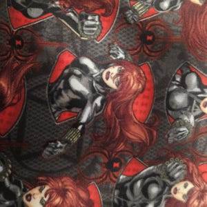 Puede incluir: Patr&oacute;n repetido con el personaje de Black Widow de Marvel Comics. El dise&ntilde;o incluye ilustraciones del personaje con un traje negro y gris, cabello rojo y un fondo rojo en forma de escudo. El fondo es gris oscuro con telara&ntilde;as y gr&aacute;ficos de ara&ntilde;as.