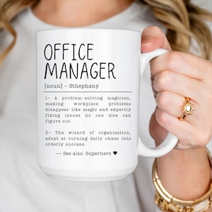 May include: White ceramic mug with a black design that reads "OFFICE MANAGER [noun] - Sthephany 1- A problem-solving magician, making workplace problems disappear like magic and expertly fixing issues no one else can figure out. 2- The wizard of organization, adept at turning daily chaos into orderly success. -- See also: Superhero"