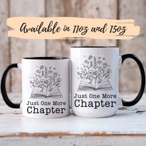 Puede incluir: Dos tazas de cer&aacute;mica blanca con bordes y asas negros. Ambas tazas presentan un dibujo en l&iacute;nea negra de un libro abierto con flores que crecen desde las p&aacute;ginas. El texto "Just One More Chapter" est&aacute; impreso en cada taza.