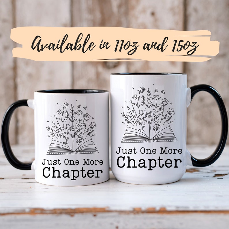 Puede incluir: Dos tazas de cer&aacute;mica blanca con bordes y asas negros. Ambas tazas presentan un dibujo en l&iacute;nea negra de un libro abierto con flores que crecen desde las p&aacute;ginas. El texto "Just One More Chapter" est&aacute; impreso en cada taza.