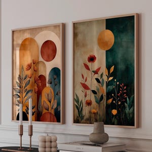Puede incluir: Dos impresiones art&iacute;sticas abstractas enmarcadas. Una presenta formas de arco en naranja, marr&oacute;n y verde azulado con detalles florales. La otra tiene un fondo dividido en beige y verde azulado con un sol amarillo y flores rojas. Los marcos son de madera clara.