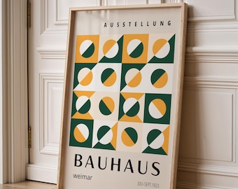 May include: A framed Bauhaus poster with a geometric design in green, yellow, and white. The poster includes the words "AUSSTELLUNG" at the top, "BAUHAUS" in large letters, and "weimar" and "JULI-SEPT.1923" at the bottom. The frame is light brown.