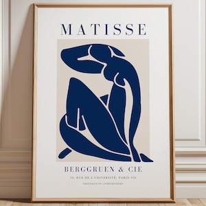Può includere: Un poster blu e beige con un'immagine stilizzata di una figura seduta. Il poster presenta il testo "MATISSE" e "BERGGRUEN & CIE" insieme all'indirizzo "70, RUE DE L'UNIVERSITÉ, PARIS-VII" e il testo "ORIGINAUX ET LITHOGRAPHIES".