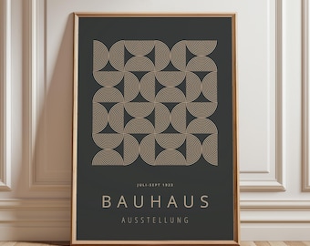 Peut inclure: Une affiche encadrée avec un motif géométrique de demi-cercles beiges sur fond gris foncé. Le texte "JULI-SEPT 1923" et "BAUHAUS AUSSTELLUNG" est présent. Le cadre est de couleur marron chaud. L'affiche est contre un mur blanc.