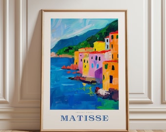 May include: A framed art print featuring a colorful coastal landscape in the style of Matisse. The artwork depicts buildings in shades of yellow, orange, pink, and purple along a blue coastline. The word "MATISSE" is printed at the bottom.
