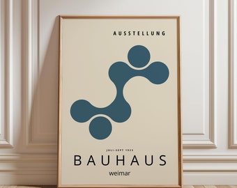 Op de afbeelding: Ingelijste Bauhaus tentoonstellingsposter. De poster heeft een turquoise abstract ontwerp op een crèmekleurige achtergrond. De tekst "AUSSTELLUNG" staat bovenaan, met "BAUHAUS weimar" onderaan. De poster zit in een houten lijst.