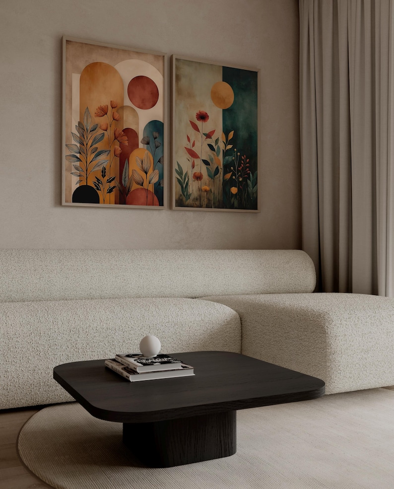 Puede incluir: Dos impresiones art&iacute;sticas enmarcadas con dise&ntilde;os florales y geom&eacute;tricos abstractos. Las impresiones presentan tonos c&aacute;lidos de naranja, rojo y amarillo, con toques de azul y verde. La obra de arte se exhibe sobre un sof&aacute; blanco y una mesa de centro de madera oscura.