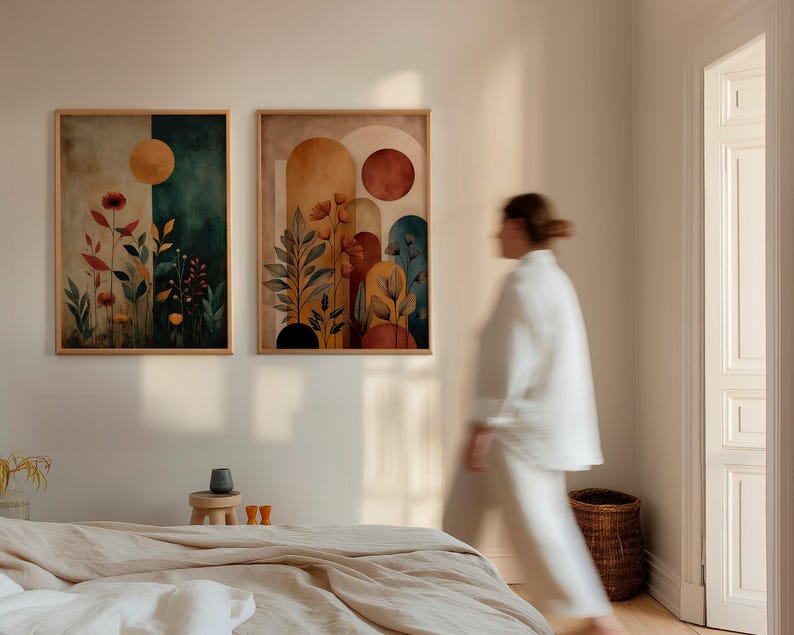 Puede incluir: Dos impresiones art&iacute;sticas en acuarela enmarcadas. Una presenta un fondo verde oscuro y beige con un sol amarillo y flores rojas. La otra tiene un fondo beige y naranja con formas de arco y flores rojas. Ambas est&aacute;n en marcos de madera clara.