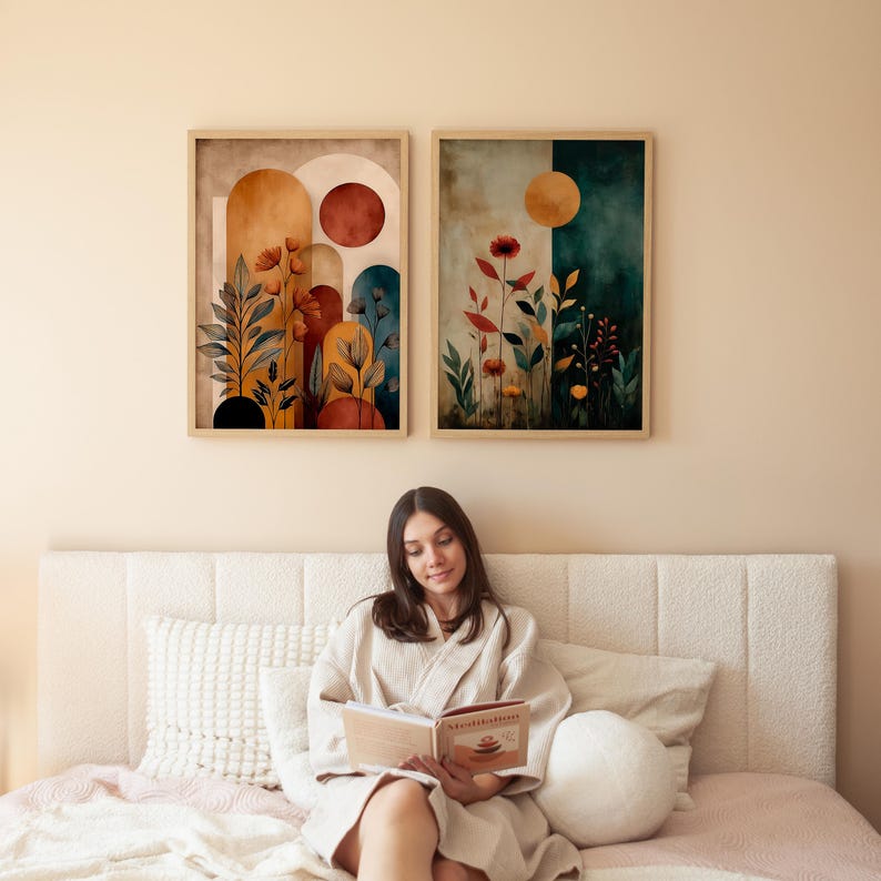 Puede incluir: Dos impresiones art&iacute;sticas bot&aacute;nicas enmarcadas con una paleta de colores neutros. La obra de arte presenta flores estilizadas, hojas y formas geom&eacute;tricas en tonos naranja, amarillo y azul. Los marcos son de color madera clara. Las impresiones est&aacute;n colgadas sobre una cama.
