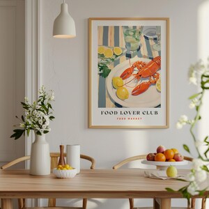 May include: A framed poster with a colorful illustration of a lobster on a plate with lemons. The poster has the text "FOOD LOVER CLUB FOOD MARKET" at the bottom.