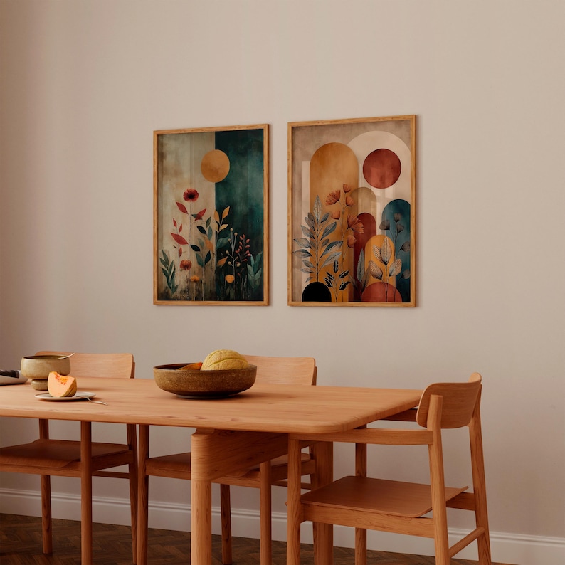 Puede incluir: Dos impresiones art&iacute;sticas bot&aacute;nicas enmarcadas con un estilo de acuarela. Una impresi&oacute;n presenta un fondo verde oscuro y beige con un sol dorado y flores rojas. La otra impresi&oacute;n tiene un fondo beige y naranja con un sol rojo y plantas estilizadas.