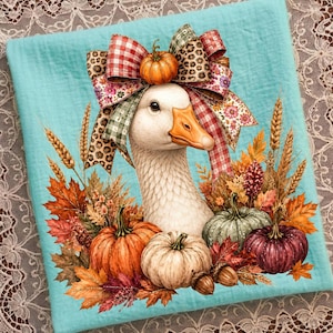 May include: A light blue fabric featuring a central illustration of a white goose with an orange beak, wearing a large multi-patterned bow with a small pumpkin on top. The goose is surrounded by autumn leaves, wheat, and colorful pumpkins.