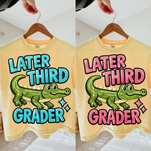 Könnte beinhalten: Zwei gelbe T-Shirts mit dem Text "Later Third Grader" und einer grünen Pailletten-Alligator-Grafik. Ein Shirt hat blauen Text und das andere rosa Text. Beide Shirts hängen an einem Holzbügel.