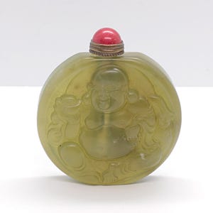 China. 1950 circa. Handcarved hardstone snuff bottle with Buddha and Tao Chi encarved.