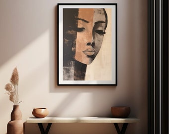 May include: A framed abstract painting of a woman's face with a black and white background and a brown and white face. The painting is hanging on a light beige wall.