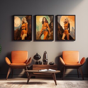 May include: Three framed illustrations of women in orange jumpsuits standing in a desert landscape. The illustrations are framed in black and hung on a grey wall.