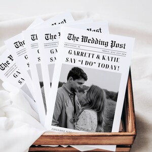 May include: Black and white wedding announcement printed to look like a newspaper with the headline "The Wedding Post" and the text "Garrett & Katie Say "I Do" Today!"  The announcement features a black and white photo of a couple.
