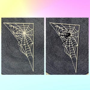 K&ouml;nnte beinhalten: Zwei dreieckige, cremefarbene Holzspinnennetzdekorationen. Eines hat eine schwarze Spinne. Die Netze sind aufwendig gestaltet mit einer zentralen Spirale und radialen Linien, perfekt f&uuml;r Halloween-Dekorationen.