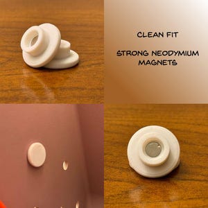 May include: White, circular magnets with a central hole are displayed. The text "CLEAN FIT" and "STRONG NEODYMIUM MAGNETS" is also visible. One magnet is shown attached to a surface.