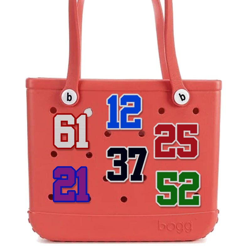 May include: A coral-colored tote bag with two handles and the word "bogg" printed on the bottom. The bag features various numbers in different colors: 61, 12, 25, 37, 52, and 21. The numbers are outlined in white.
