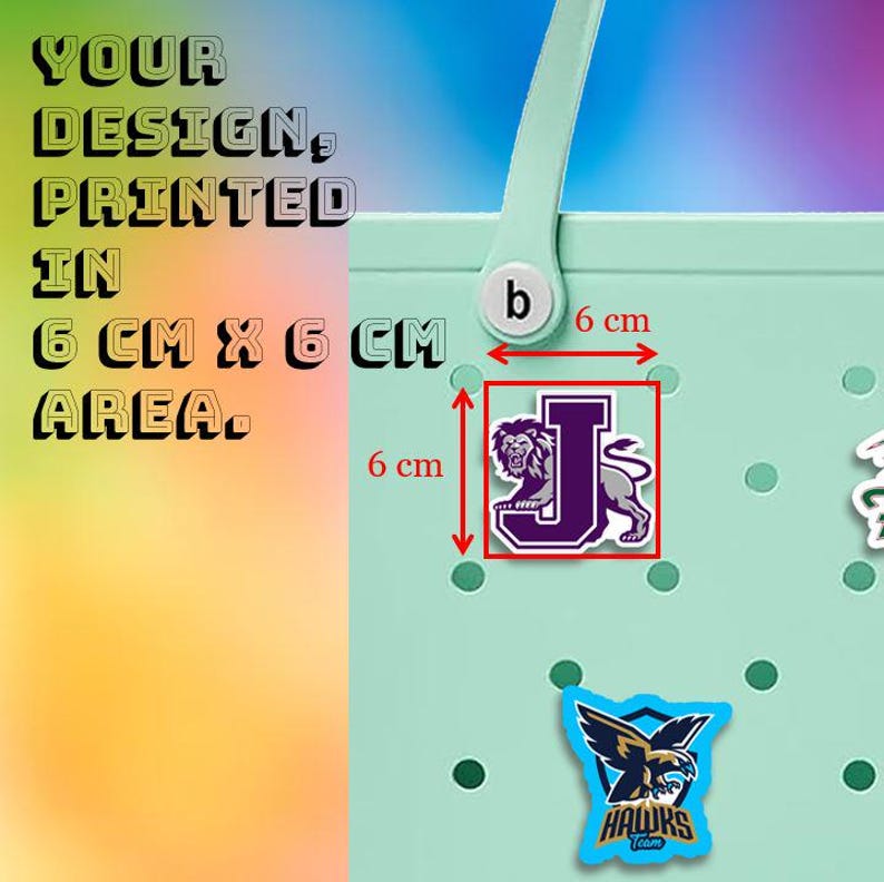 May include: A light green tote bag with a white handle. The image shows a purple and white lion graphic on a 6 cm x 6 cm area. The text reads "YOUR DESIGN, PRINTED IN 6 CM X 6 CM AREA."