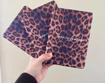 May include: Three leopard print e-reader covers with the text "shhh i'm reading" on one of the covers.
