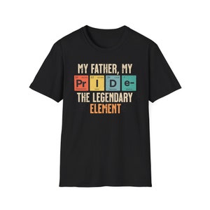 Puede incluir: Camiseta negra con un gráfico de la palabra "PRIDE" deletreada usando símbolos de elementos químicos. El texto "My Father, My" está por encima del gráfico y "The Legendary Element" está por debajo.