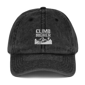 May include: A black vintage washed cotton baseball cap with white embroidered text that reads "CLIMB HIGHER" and a mountain graphic.