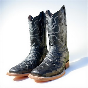 May include: A pair of black cowboy boots with a square toe and a textured, diamond-patterned vamp. The boots have decorative white stitching on the shaft and a light brown sole. The boots are set against a white background.