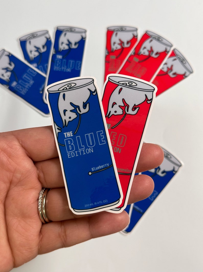 Pu&ograve; includere: Una collezione di adesivi con un design stilizzato di una lattina di energy drink. Gli adesivi sono blu e rossi, con la scritta "THE BLUE EDITION" e "THE RED EDITION". L'adesivo blu &egrave; etichettato "Blueberry" e quello rosso "Watermelon". Ogni lattina &egrave; da 250 ml.
