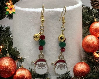 May include: A pair of gold dangle earrings with a Santa Claus charm, red and green beads, and gold bells.